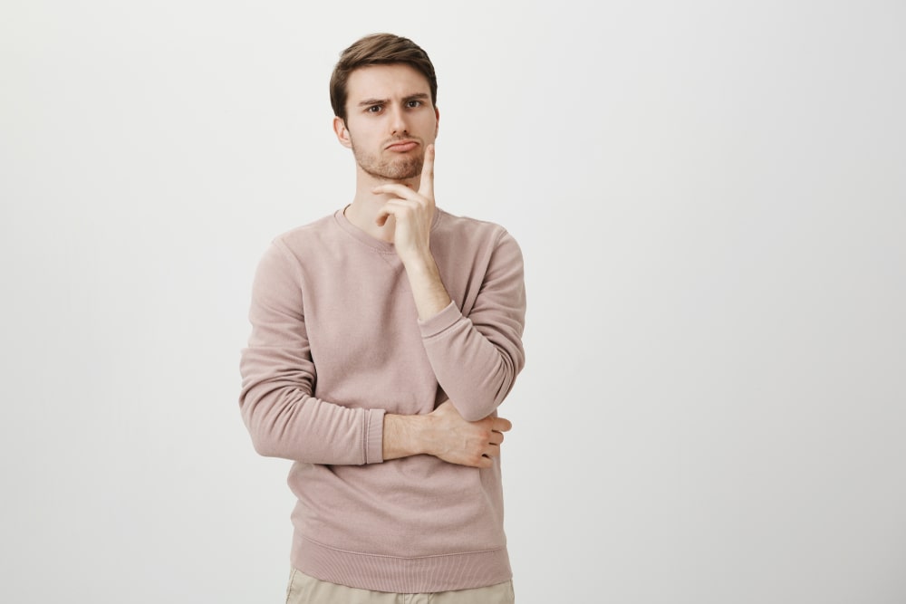 Man thinking with arms crossed and finger on his face